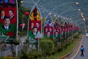 A Pakistani police officer walks pasts billboards showing pictures of Chinese President Xi Jinping, Pakistan’s President Mamnoon Hussain and Prime Minister Nawaz Sharif, Islamabad, Pakistan, April 19, 2015 (AP photo by Anjum Naveed).