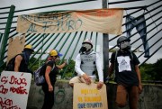 Venezuelan protesters wearing helmets and gas masks near La Carlota air base, Caracas, June 24, 2017 (AP photo by Ariana Cubillos).