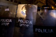 Police, whose shields carry anti-President Evo Morales stickers placed by demonstrators, block protesters from reaching the National Palace where Evo Morales has his offices in La Paz, Bolivia, Nov. 30, 2017 (AP photo by Juan Karita).