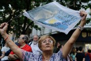 A woman holds a flag decorated with a picture of Argentina’s former president, Cristina Fernandez, during a rally to show support for her, Buenos Aires, Argentina, Dec. 7, 2017 (AP photo by Natacha Pisarenko).