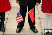 A person holds Chinese and American flags at a welcome ceremony with President Donald Trump and Chinese President Xi Jinping at the Great Hall of the People, Beijing, Nov. 9, 2017 (AP photo by Andrew Harnik).