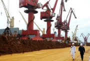 Chinese inspectors walk past piles of rare earth on a quay at the Port of Lianyungang in Jiangsu province, China, May 22, 2016 (Photo by Wang Chun for Imaginechina via AP Images).