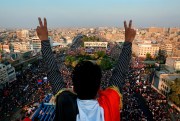 A protester flashes the victory sign overlooking a huge anti-government rally in Tahrir Square, Baghdad, Iraq, Oct. 31, 2019 (AP photo by Hadi Mizban).