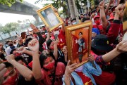 Burmese living in Thailand hold pictures of Myanmar leader Aung San Suu Kyi during a protest in front of the Myanmar Embassy, in Bangkok, Thailand, Feb. 1, 2021 (AP photo by Sakchai Lalit).