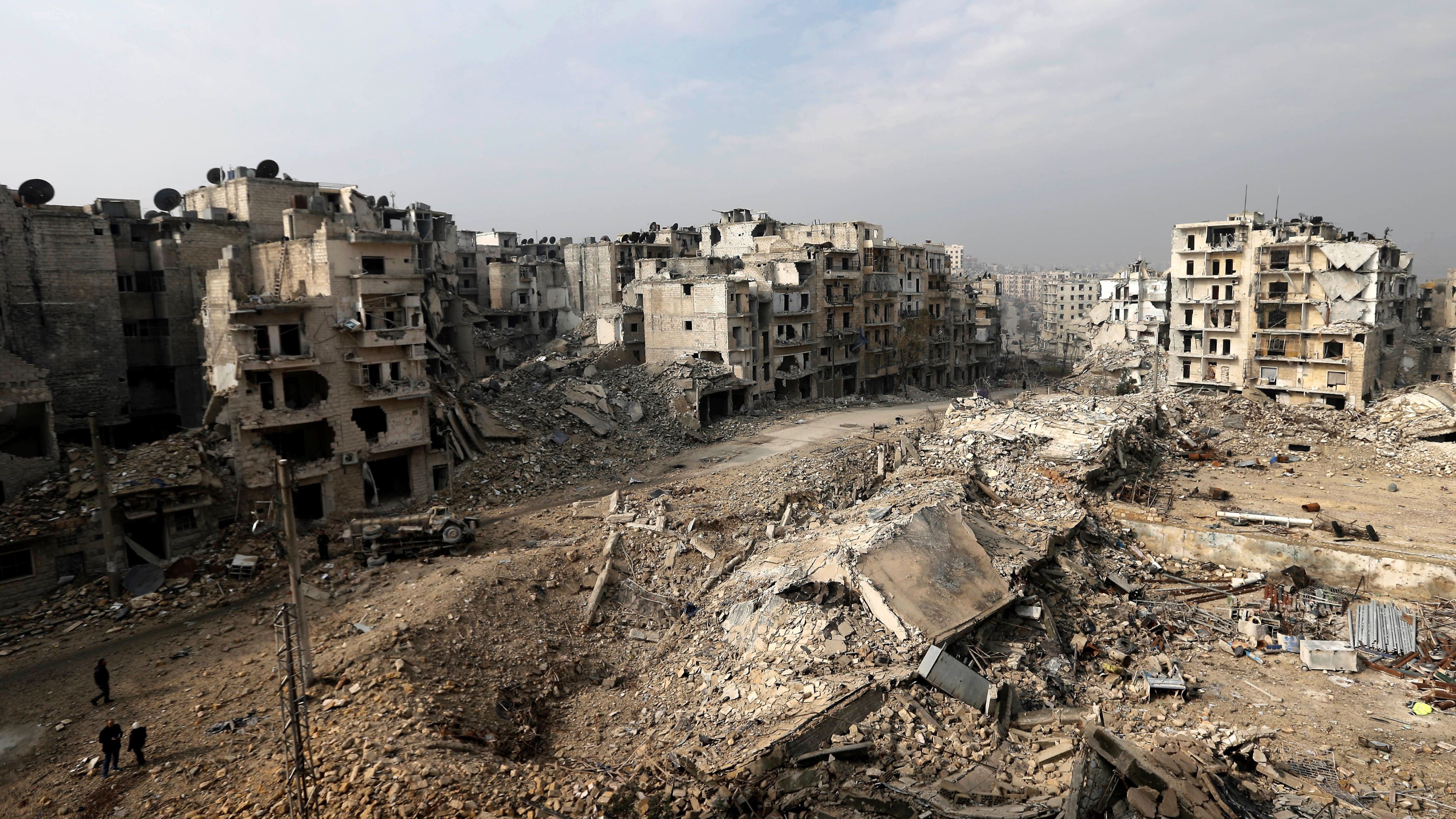 People locomotion done mounds of rubble that utilized to beryllium high-rise flat buildings successful Aleppo, Syria.