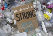 A sign reading “We demand a strong global plastics treaty."