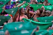 Women hold up green bandanas, a symbol of abortion rights in Latin America.