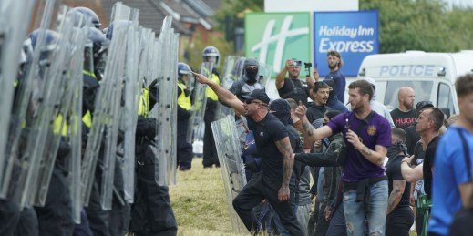 Police officers defend a hotel housing asylum-seekers from a violent far-right mob in the UK.