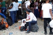 People wait at Toussaint Louverture International Airport after the Haitian government banned all charter flights to Nicaragua.