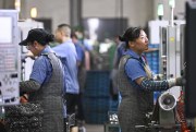 Workers produce gears at a workshop at a gear factory in Taizhou, Jiangsu province, China.