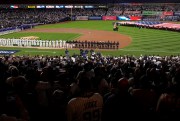 A U.S. flag covers the outfield during a baseball game.