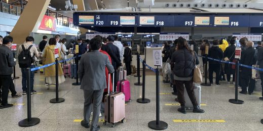 Travelers wait in line at a check-in counter at Kunming Changshui International Airport.