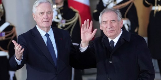 Outgoing French Prime Minister Michel Barnier, left, welcomes newly named Prime Minister François Bayrou.