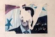 A torn poster showing the face of former Syrian dictator Bashar al-Assad.