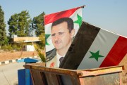 Posters of Syrian President Bashar al-Assad in a dumpster.