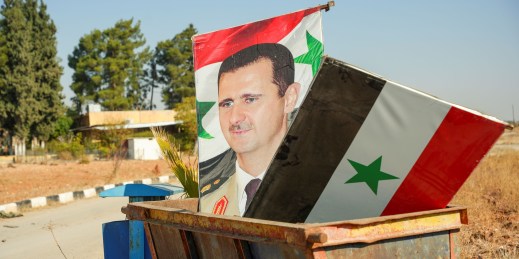 Posters of Syrian President Bashar al-Assad in a dumpster.