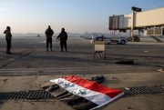 A Syrian flag lies on the ground at Aleppo Airport.