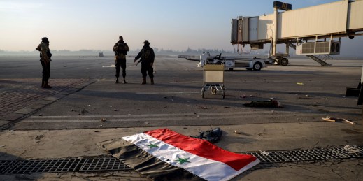 A Syrian flag lies on the ground at Aleppo Airport.